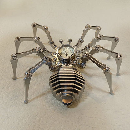 Steel spider clock ornament photographed at an angle with warm light catching the segmented abdomen