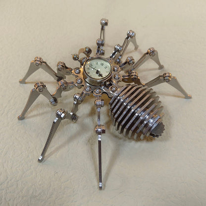 Stainless steel spider desk ornament seen from a raised angle showing the domed clock and leg joints