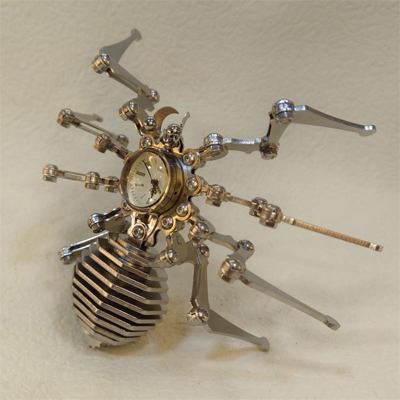 Top-down view of stainless steel spider figurine with eight jointed legs spread wide on a cream background