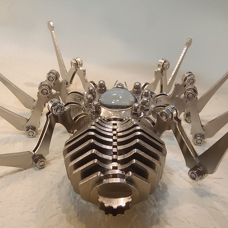 Front view of the spider sculpture showing stacked abdomen plates and a glossy dome head