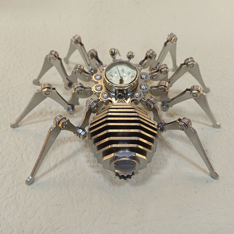Close view of the spider sculpture with a golden sheen on the abdomen plates around the Roman numeral clock face