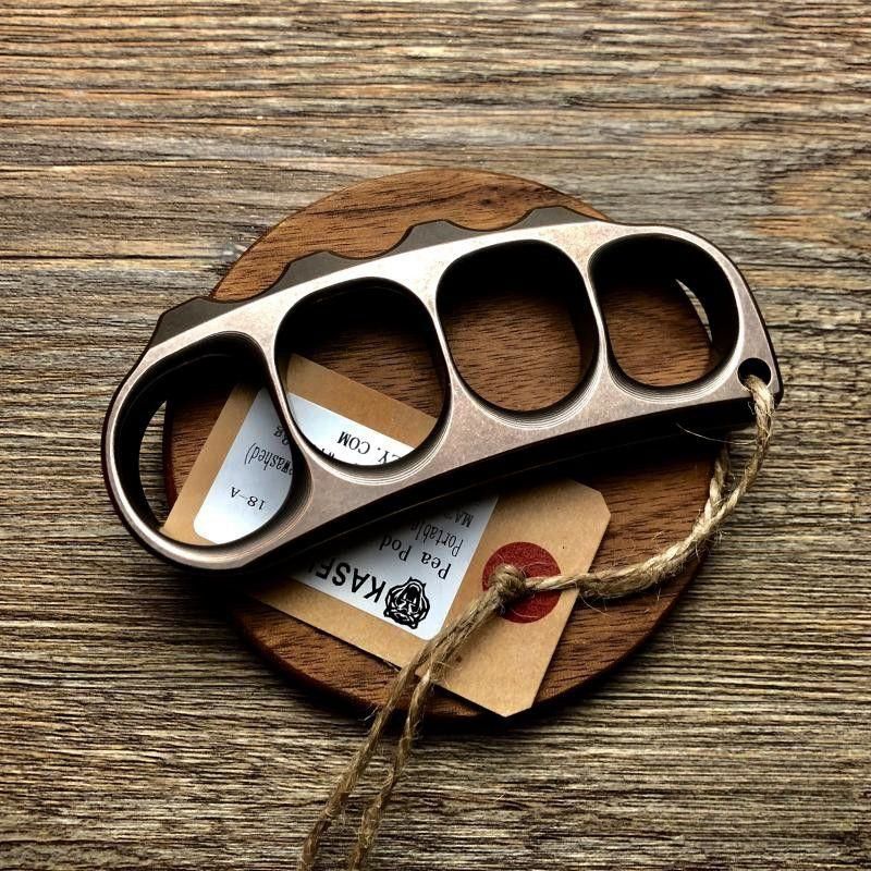 Bronze toned steel knuckle lying on a round wooden coaster with a kraft tag tied by twine