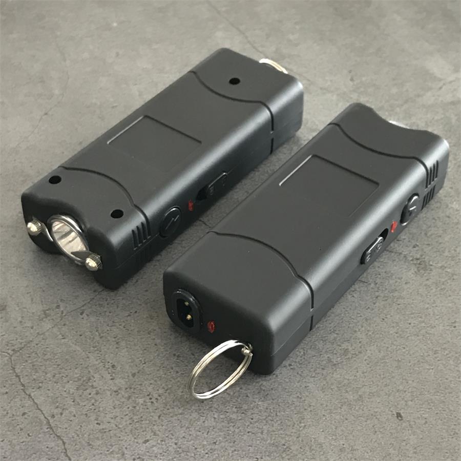 Black 801C stun gun held in a white-gloved hand showing the palm-sized grip and light end