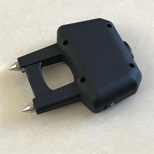 Back of the matte black single-hole stun device with the central finger hole and two electrode prongs.