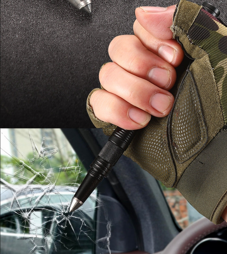 A gloved hand grips the black tactical pen and drives its pointed tip into a car window, shattering the glass in a spiderweb crack, demonstrating the window-break cone.
