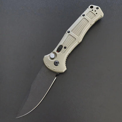 Tan-green handle folder open with a plain drop-point blade on a grey surface