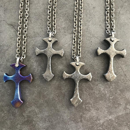 Blaze, Titan, Relic and Obsidian TC21 titanium cross pendants arranged on dark stone surface