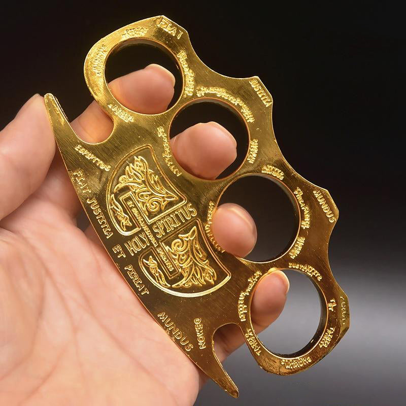 Golden knuckle duster with an engraved shield emblem and border lettering held in an open hand
