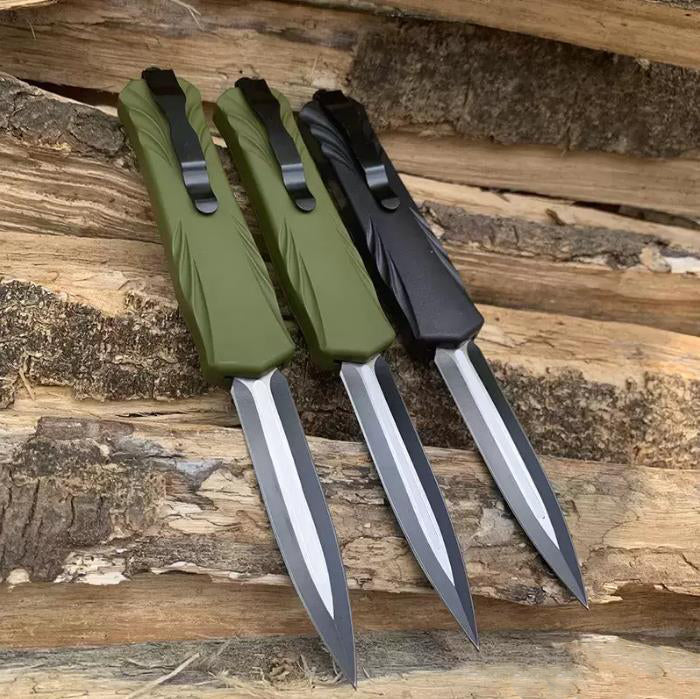 Three automatic OTF pocket knives aligned point-down on weathered wood