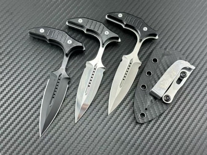 Three A2 steel push daggers with black G10 T-handles in Black Blade, Sanding, and Mirror light finishes with carbon fiber sheath