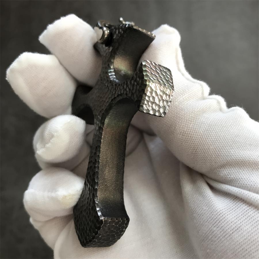 Side profile of Titan finish titanium cross pendant showing raw gray hammered thickness