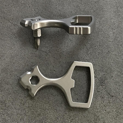 Titanium opener tool with a Phillips bit seated in the hex socket above a second tool laid flat
