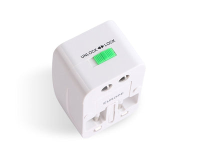 Top-down view of the white travel adapter showing the green unlock lock slider and the EUROPE side fold-out pin mechanism