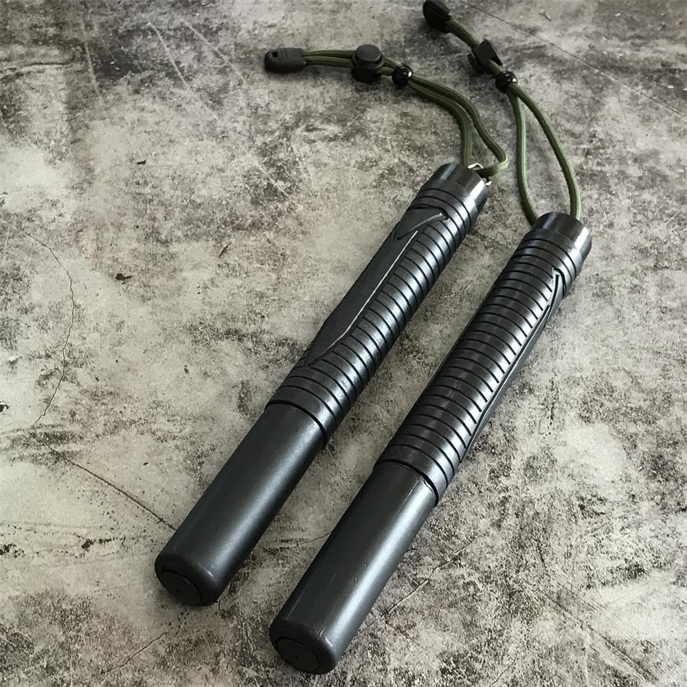 Two collapsed batons side by side on concrete, each with a green cord