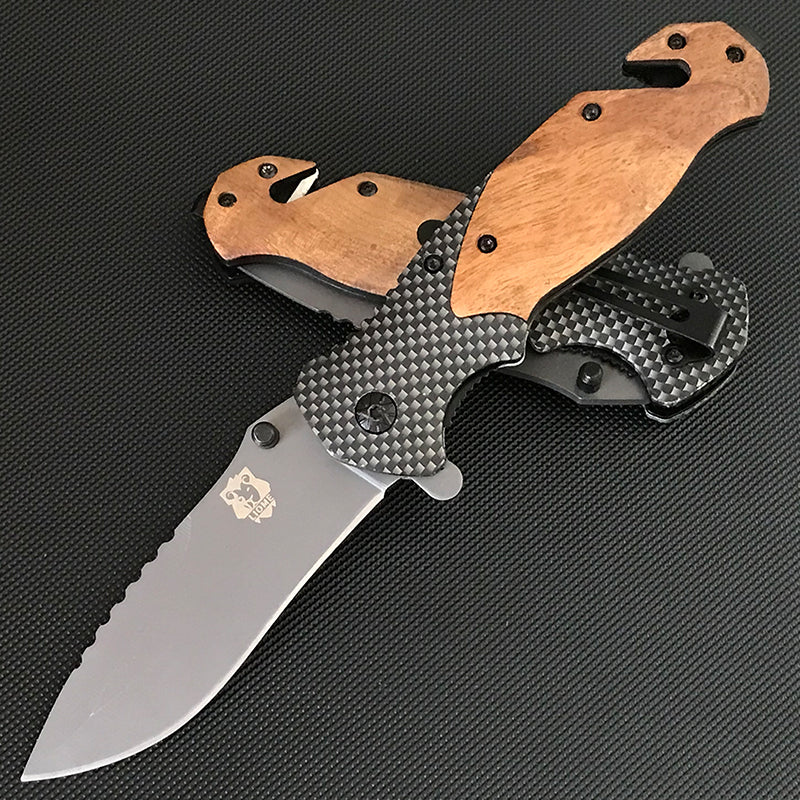 Two X50 folding knives crossed showing the wooden front scales and the carbon fiber pattern back with pocket clip