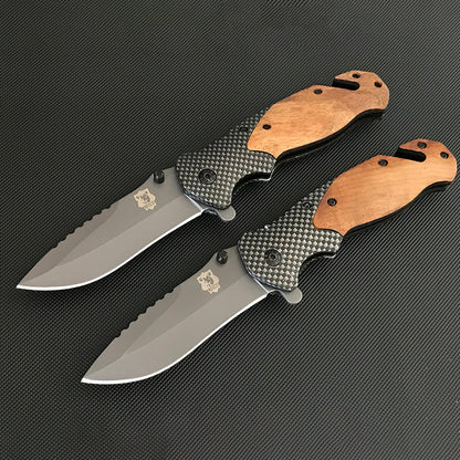 Two open Liome X50 folding knives in parallel showing wooden scales, carbon fiber pattern mid-bodies and sawback blades