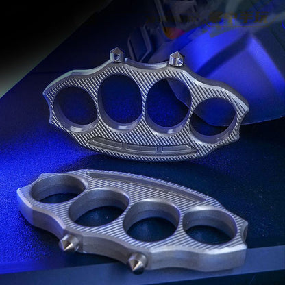 Two zinc-alloy knuckle dusters with four finger holes and detachable window-breaking cones under blue lighting