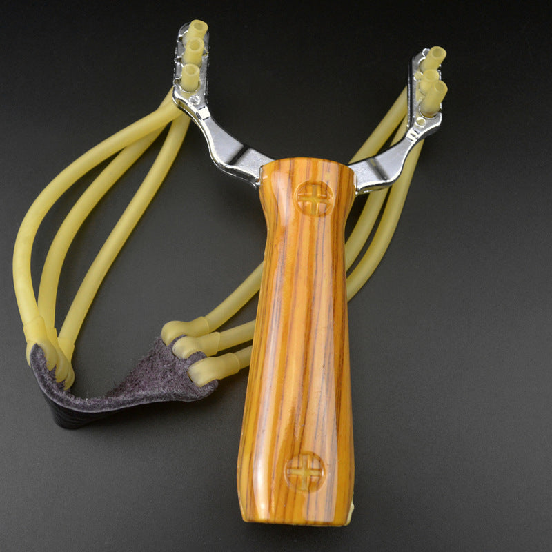 Wood grain water transfer slingshot with yellow band strands and dark leather pouch standing on a dark grey background